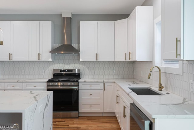 kitchen featuring wall chimney range hood, sink, white cabinetry, black dishwasher, and gas range