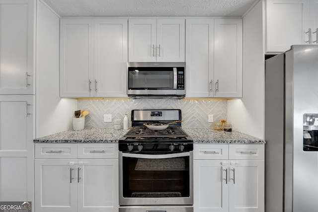 kitchen with white cabinetry, light stone countertops, and appliances with stainless steel finishes