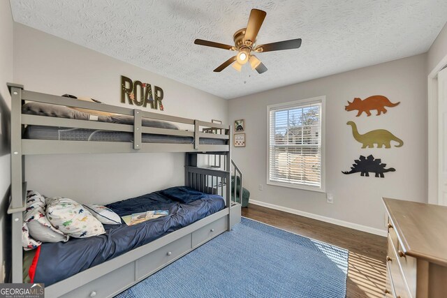 bedroom featuring high vaulted ceiling, hardwood / wood-style flooring, ceiling fan, a textured ceiling, and a closet