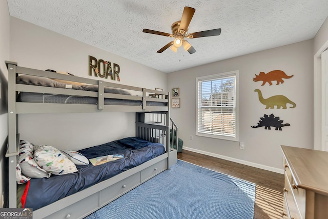 bedroom featuring ceiling fan, dark wood-type flooring, and a textured ceiling