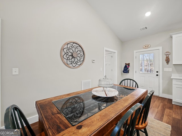 dining room featuring vaulted ceiling and dark hardwood / wood-style floors