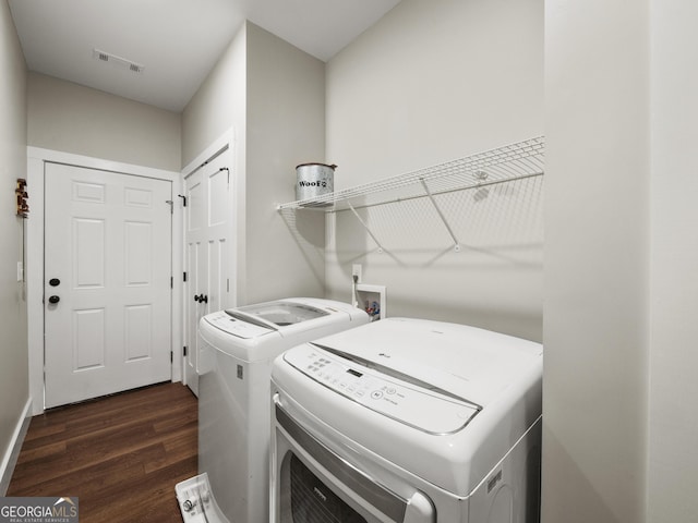 washroom featuring dark wood-type flooring and washing machine and clothes dryer