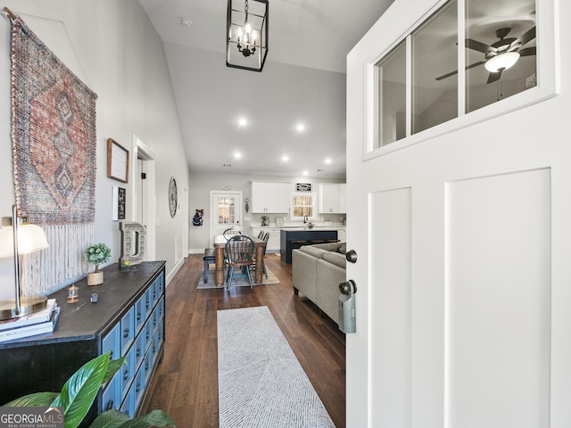 entryway featuring sink, ceiling fan with notable chandelier, dark wood-type flooring, and high vaulted ceiling