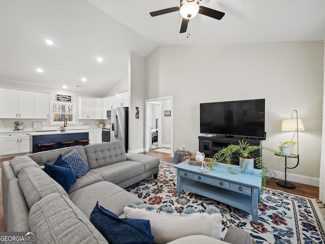 living room featuring hardwood / wood-style flooring, high vaulted ceiling, and ceiling fan