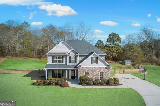 view of front of property with a front yard and a shed