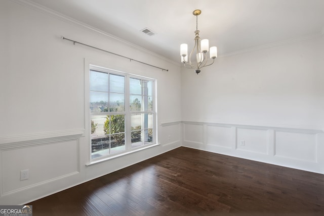 unfurnished room with ornamental molding, dark wood-type flooring, and an inviting chandelier