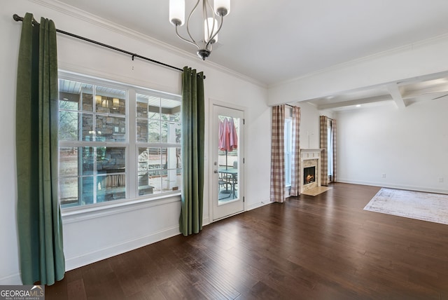 unfurnished living room featuring beamed ceiling, crown molding, an inviting chandelier, and dark hardwood / wood-style flooring