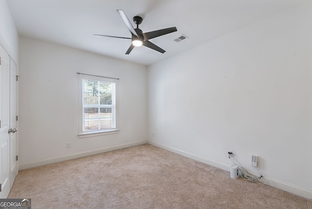 carpeted spare room with ceiling fan