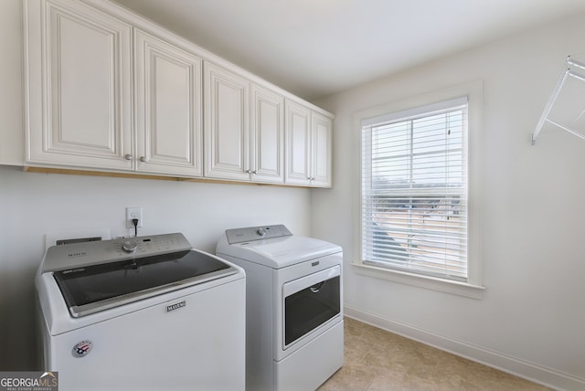 washroom with separate washer and dryer and cabinets