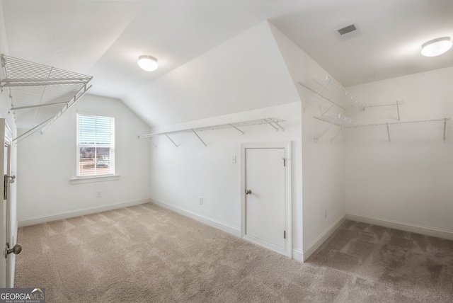 walk in closet with lofted ceiling and carpet flooring