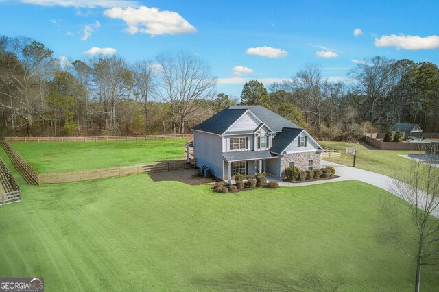 view of front facade featuring a rural view, a front lawn, and a porch