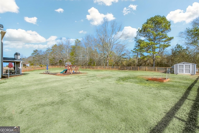 view of yard featuring a playground and a shed