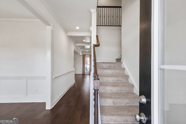 staircase featuring ornamental molding and hardwood / wood-style floors