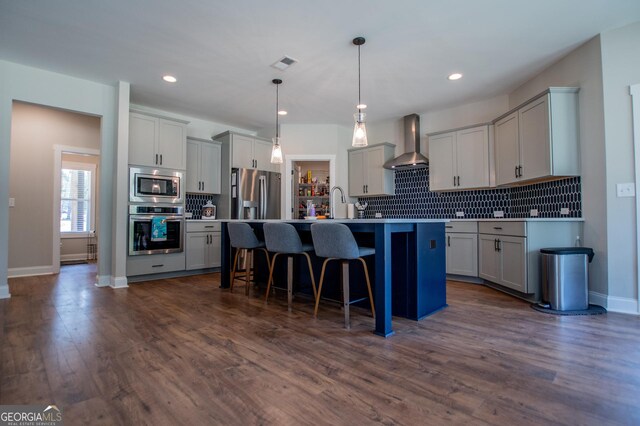 1291 Pleasant Grove Church Rd, Villa Rica, GA 30180 - kitchen featuring a breakfast bar, appliances with stainless steel finishes, hanging light fixtures, an island with sink, and wall chimney exhaust hood
