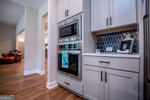 1291 Pleasant Grove Church Rd, Villa Rica, GA 30180 - kitchen featuring white cabinetry, appliances with stainless steel finishes, dark hardwood / wood-style floors, and decorative backsplash