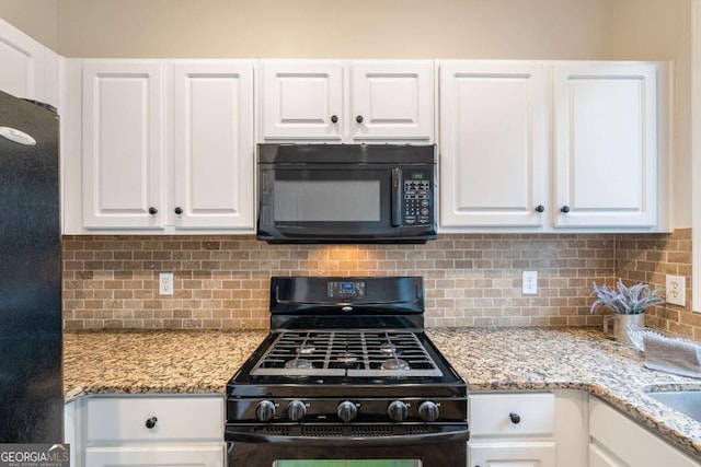 kitchen featuring backsplash, white cabinets, light stone countertops, and black appliances