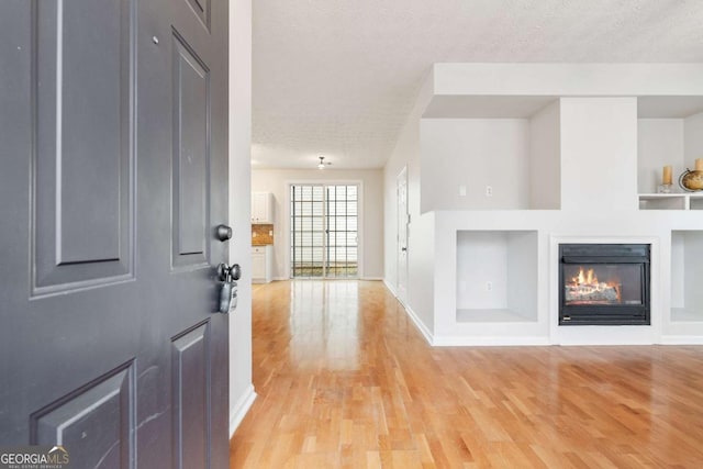 foyer entrance featuring a textured ceiling and light hardwood / wood-style floors