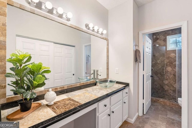 bathroom with a shower with door, vanity, and toilet