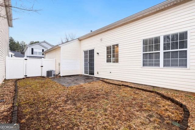 rear view of house with central AC and a patio area