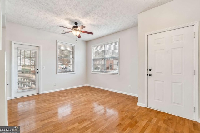 foyer featuring hardwood / wood-style flooring, ceiling fan, and a textured ceiling