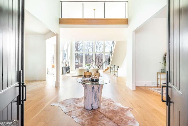 foyer featuring a towering ceiling and light hardwood / wood-style floors