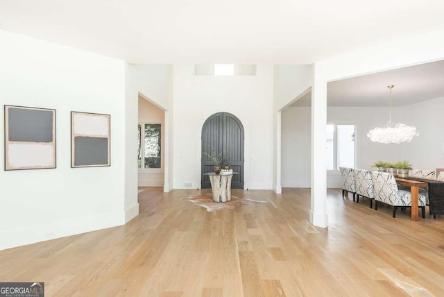 foyer with an inviting chandelier, plenty of natural light, and light wood-type flooring