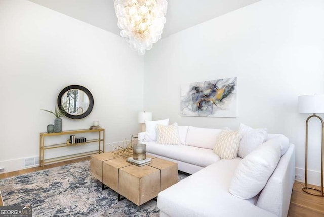 living room with wood-type flooring and a chandelier