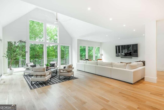 living room featuring ceiling fan, high vaulted ceiling, and light hardwood / wood-style floors