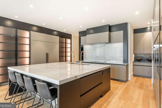 kitchen featuring a large island, sink, and gray cabinetry