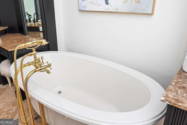 bathroom with tile patterned flooring, vanity, and a bath