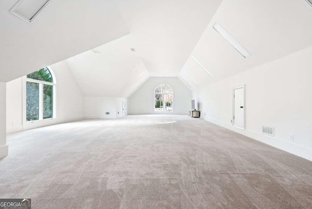 additional living space with lofted ceiling and light carpet