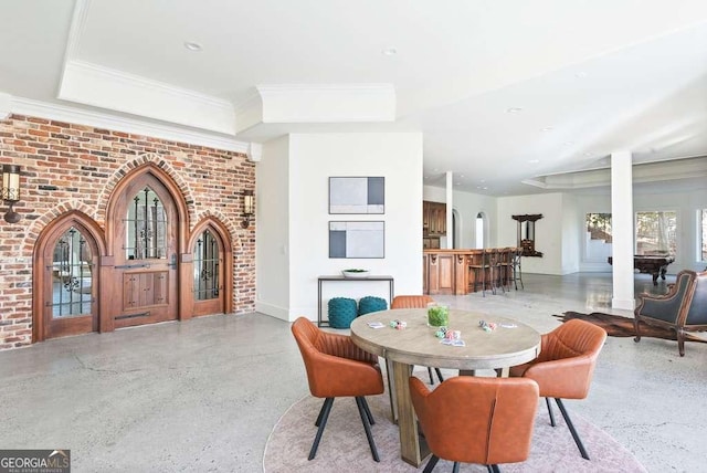 dining room featuring ornamental molding and brick wall