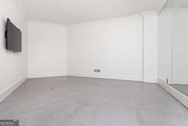 empty room featuring crown molding and concrete floors