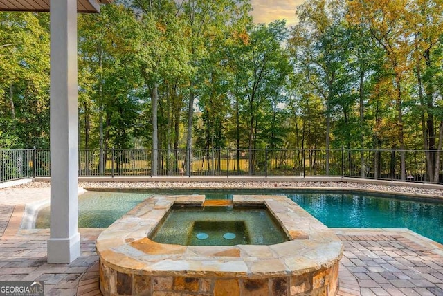 view of pool featuring a patio and an in ground hot tub