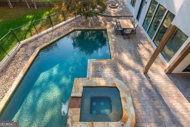 view of pool with an in ground hot tub and a patio area