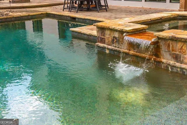 view of swimming pool with an in ground hot tub