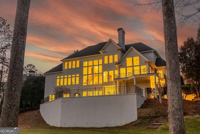 back house at dusk with a balcony