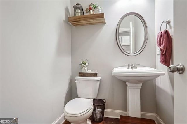 bathroom with hardwood / wood-style flooring and toilet