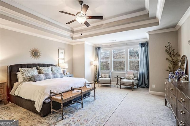 carpeted bedroom with ceiling fan, ornamental molding, and a raised ceiling