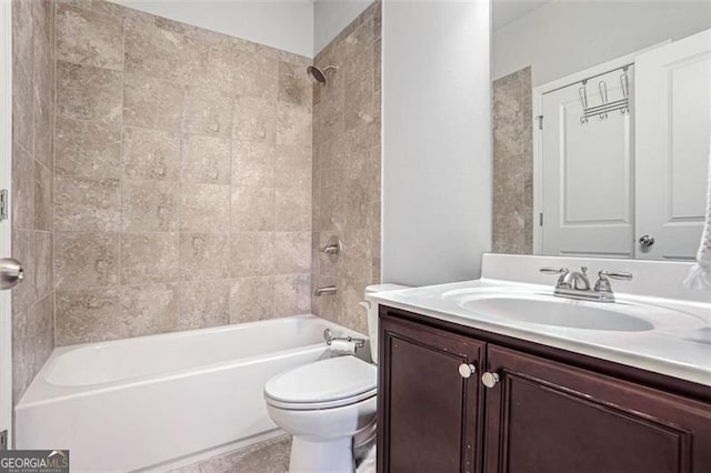 full bathroom featuring tiled shower / bath, vanity, and toilet