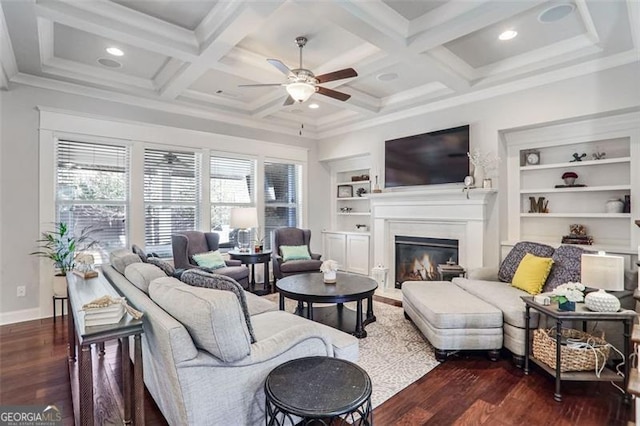 living room featuring coffered ceiling, dark hardwood / wood-style floors, built in features, beamed ceiling, and ceiling fan