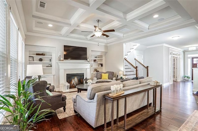 living room featuring coffered ceiling, crown molding, dark hardwood / wood-style floors, built in features, and beamed ceiling