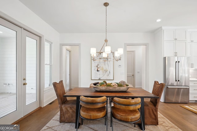 dining space with a wealth of natural light, light hardwood / wood-style flooring, and french doors