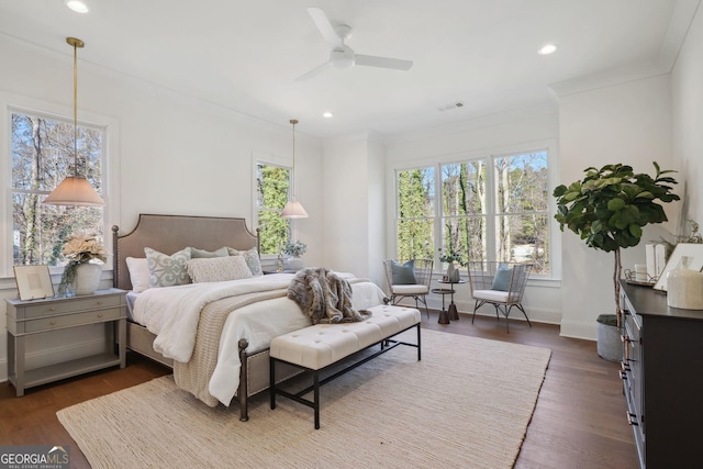 bedroom with crown molding, dark wood-type flooring, and ceiling fan