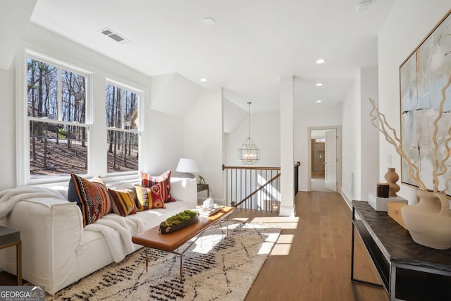 living room with an inviting chandelier and light wood-type flooring