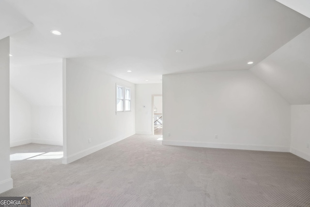 additional living space with vaulted ceiling and light colored carpet