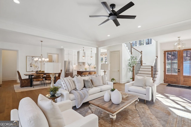 living room featuring ceiling fan with notable chandelier and dark hardwood / wood-style flooring