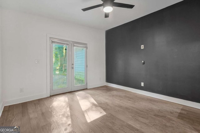 unfurnished room with ceiling fan, light hardwood / wood-style floors, and french doors