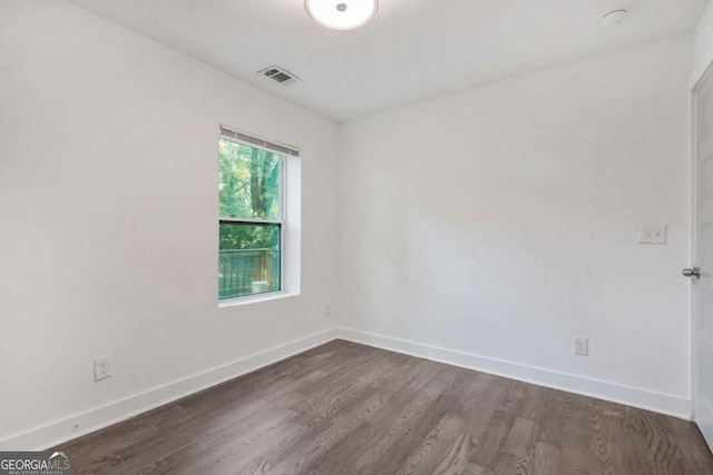 unfurnished room with dark wood-type flooring