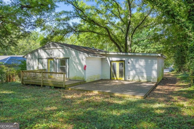 rear view of house with a lawn, a patio, and a deck